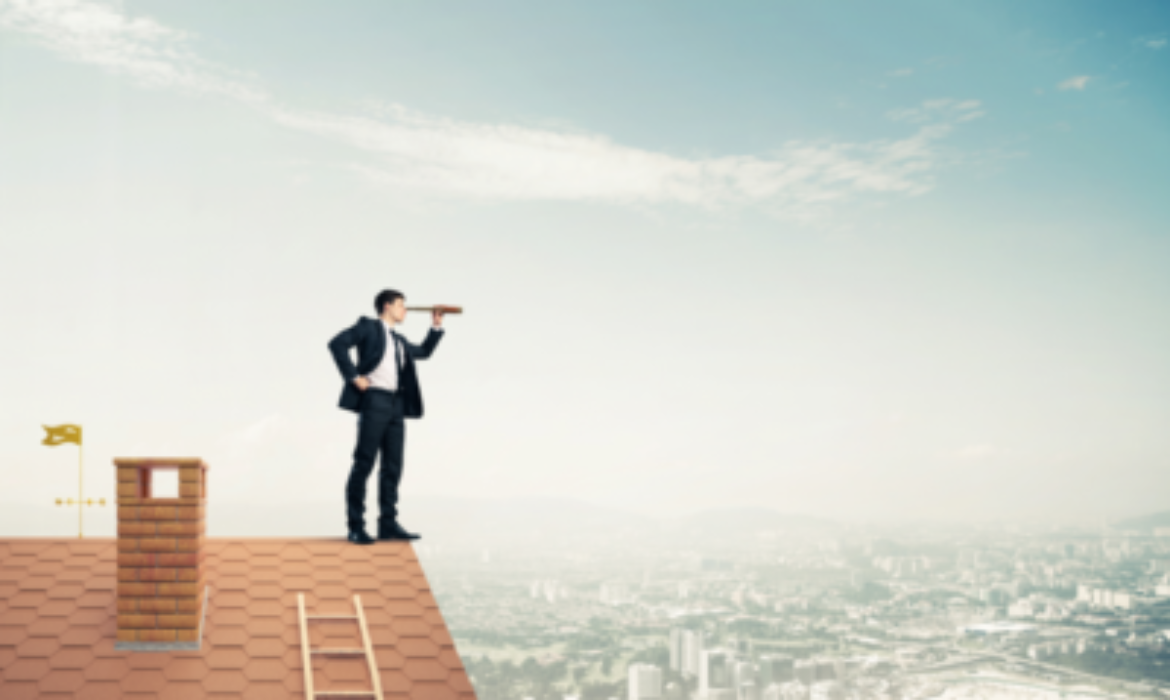 Un homme en costume se tient au bord d’un toit, tenant un télescope, regardant un vaste paysage urbain. Une cheminée et un petit drapeau sont visibles à côté de lui, ainsi qu'une échelle appuyée contre le toit. Le ciel est bleu avec quelques nuages, reflétant la façon dont le coronavirus a provoqué la mise en pause du marché immobilier.